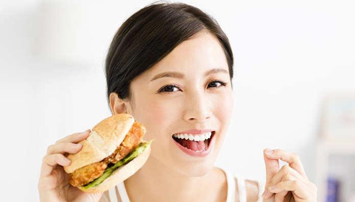ハンバーガーを食べる女性